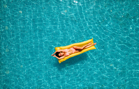 Girl in swimsuit who tan in a swimming pool