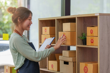 A portrait of Asian woman, e-commerce employee freelance with parcel box for deliver to customer. Online marketing packing box delivery concept.