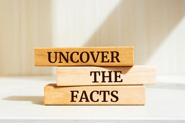 Wooden blocks with words 'UNCOVER THE FACTS'.
