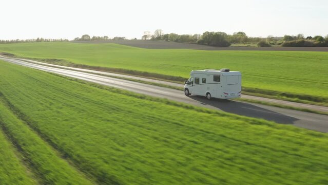 Drone Over Campervan Driving Along Road Through Green Fields