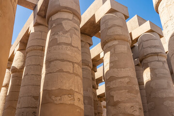 Colonnade in the hypostyle hall of the Karnak Temple of Luxor. Rows of tall ancient columns against...