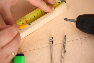 Foreman draw line on wooden piece, use measure tape and pencil