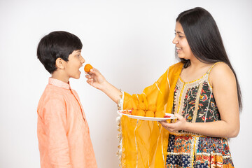 Young Indian brother and sister celebrating Diwali, rakshabandhan or bhai dooj festival isolated on...