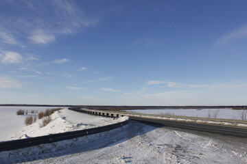 A snow-covered highway in Ugra. A highway outside the city in the North. Snow on the roadsides and frost