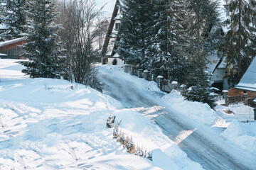 A trail in the pine wood covered with snow after heavy and severe snowfall. Snowy road in the forest at winter
