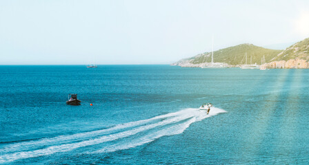 Turquoise mediterranean bay with boats under the summer sun. Active recreation concept.