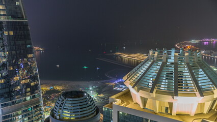 Obraz premium Aerial view of JBR and Dubai Marina skyscrapers and luxury buildings night timelapse from above