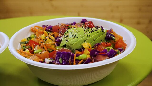 Colorful salad topped with avocado and sesame seeds, poke bowl, slider close up 4K