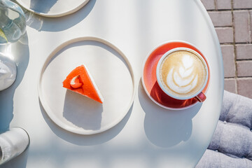 Cup of latte coffee with cheesecake top view.