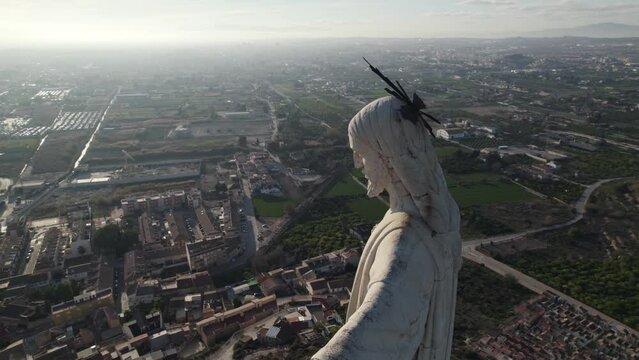 Close-up aerial orbit at Christ of Monteagudo statue overlooking Murcia