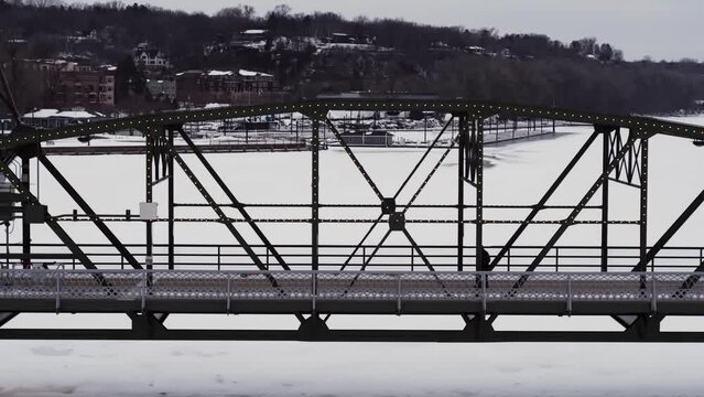 Silhouetted against fresh white snow, a man walks across the Arcola high bridge in Stillwater, Minnesota