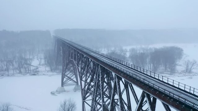 Aerial shot flying alongside the Soo Line High Bridge, also known as the Arcola High Bridge, a steel deck arch bridge over the St. Croix River between Stillwater, Minnesota and Somerset, Wisconsin,