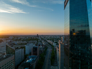 Centrum Warszawy, widok na wieżowce i biurowce, zbliżenie z lotu ptaka z drona, zachód słońca, wiosna, niebieskie niebo