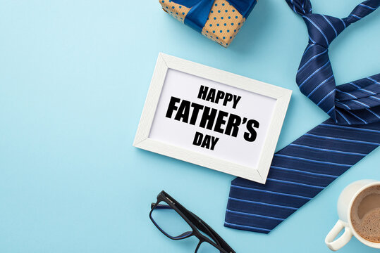 Father's Day concept. Top view photo of white photo frame cup of coffee glasses giftbox and blue necktie on isolated pastel blue background with blank space