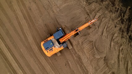 Aerial view of the excavator. The excavator prepares the road from sand for laying asphalt.