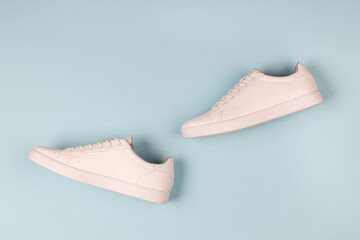 Pair of new white sneakers on blue background
