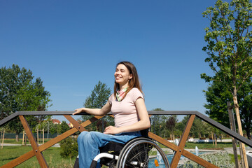 A woman smiling, enjoying and appreciating a pleasant summer day alone in her wheelchair