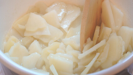 スライスしたじゃがいもを片手鍋で加熱していく様子