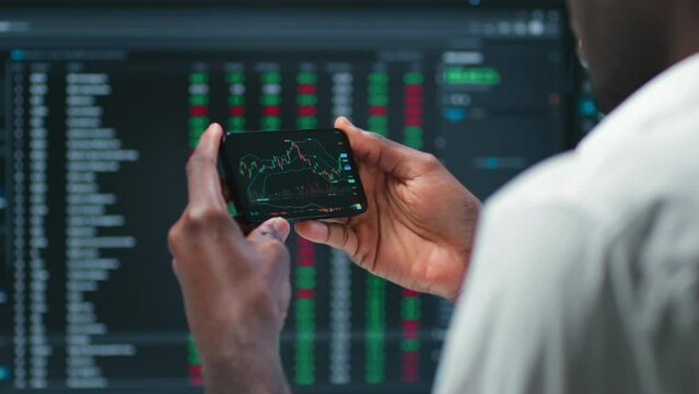 Cropped shot of male stock market broker analyzing graphs on smartphone 