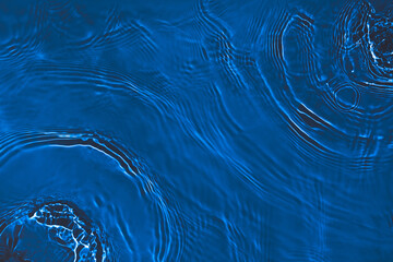 Transparent dark blue clear water surface texture with ripples, splashes. Abstract nature...