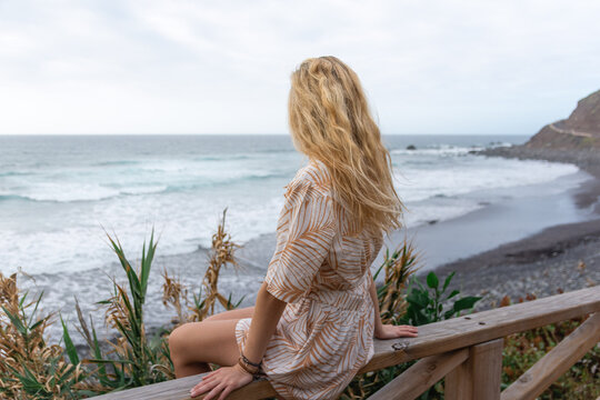 Portrait of a young beautiful blonde-haired seen from behind on the beach