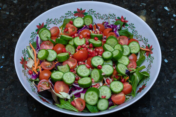 Delicious looking and healthy bowl of Salad with tomatoes, cucumber, lettuce, onion, olives and more