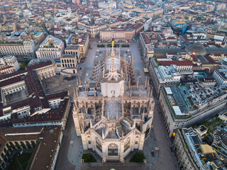 Aerial view of Duomo di Milano Cathedral in Duomo Square. Gothic cathedral in the center of Milan. Drone view of the gallery and Milano rooftops, in north Italy, Lombardia. Birds eye of Duomo facade.