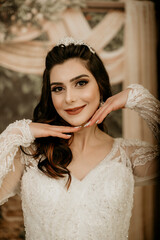 Beautiful bride posing in wedding dress in photo Studio. Beauty portrait of bride wearing fashion wedding dress with feathers with luxury delight make-up and hairstyle. Young attractive Kurdish model.