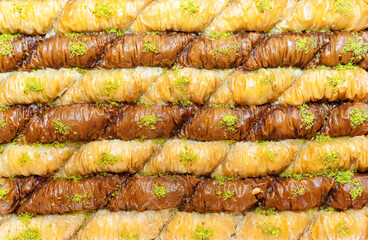 Slices of traditional pistachio and cocoa turkish baklava background. Traditonal eastern sweet...