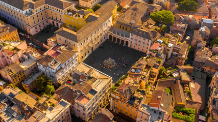 Aerial view at sunset of Piazza Santa Maria in Trastevere in Rome, Italy. In the center of the...