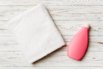 Cosmetic shampoo bottle mockup with towels on a colored table. Bathroom background, toilet accessories for hand and body care