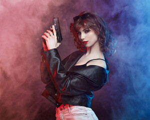 beautiful young Caucasian girl with bright red lips poses with a gun.