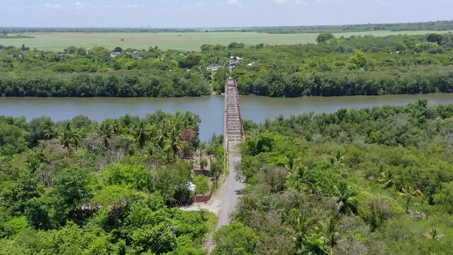 Aerial view of old bridge over the Soco River during sunlight and rural landscape in background
