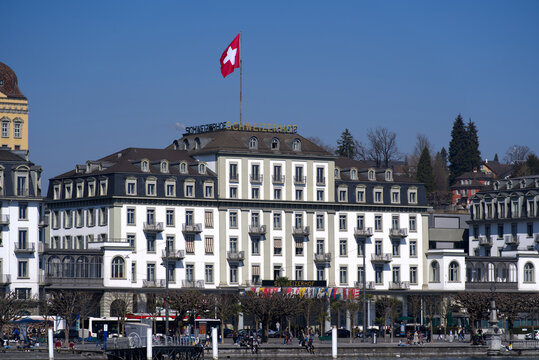 Cityscape of Luzern with luxury hotel Schweizerhof with flags of all cantons on a sunny winter day. Photo taken March 23rd, 2022, Lucerne, Switzerland.