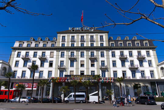 Cityscape of Luzern with luxury hotel Schweizerhof with flags of all cantons on a sunny winter day. Photo taken March 23rd, 2022, Lucerne, Switzerland.