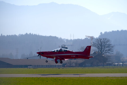 Pilatus PC-21 Airplane Landing At Swiss Air Base Emmen With Swiss Alps In The Background On A Sunny Spring Day. Photo Taken March 23rd, 2022, Emmen, Switzerland.