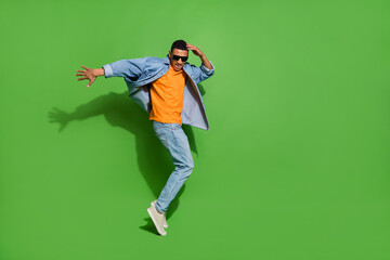 Full body image of good mood young man have fun relaxing on weekend in nightclub isolated on green color background - obrazy, fototapety, plakaty