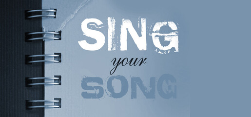 Sing your song text message words on yellow page of copybook in white and blue. Music concept