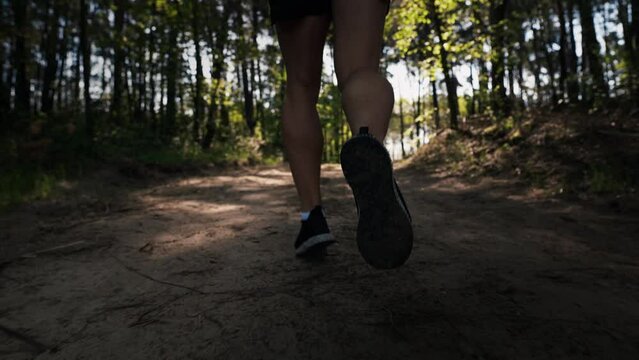 Close-up of legs running in forest