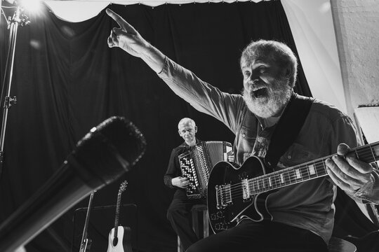 Two Senior Men, Musicians Playing Electric Guitar And Accordion. Repetition Of Retro Music Band At Music Studio. Concept Of Art, Music, Style And Creation. Monochrome