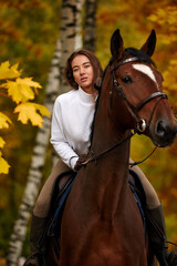 Fototapeta premium Cowgirl in a cowboy hat rides a horse on the background of the forest. Motion blur effect.