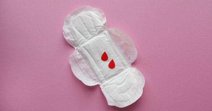 Women's sanitary napkins and drops of blood cut out of paper. Menstrual cycle. Looped 4K stop motion animation