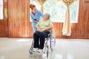 Freundliche Altenpflegerin und Seniorin im Rollstuhl