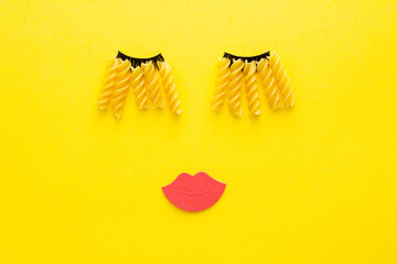 Eyelashes made of macaroni pasta and big pink lips. 80s beauty industry. Make up idea. 