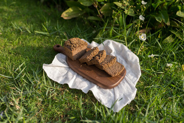 Composition of homemade custard bread on wood board with white cloth napkin on the green grass. High quality photo