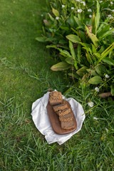 Composition of homemade custard bread on wood board with white cloth napkin on the green grass. High quality photo