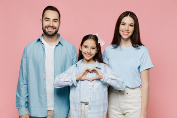 Young parents mom dad with child kid daughter teen girl in blue clothes showing shape heart with...