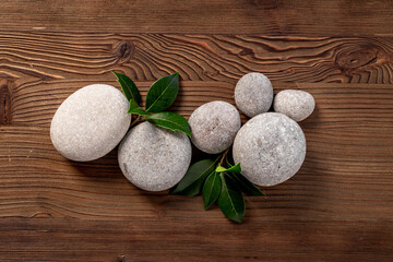 Spa massage stones with green leaves. Beauty treatment background