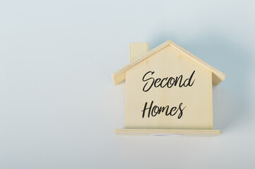 Wooden house model with text SECOND HOMES