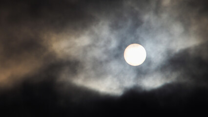 Naklejka na ściany i meble Vue rapprochée de la Lune, partiellement couverte par des nuages bas translucides
